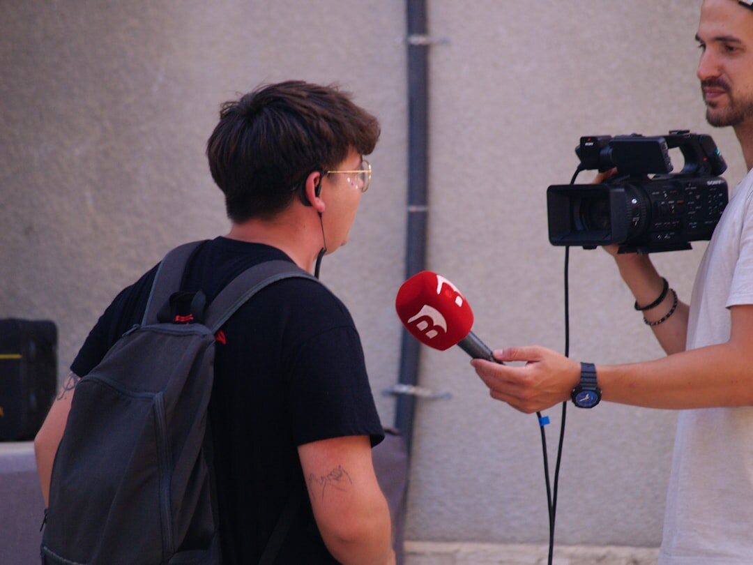 Reporter speaking on camera in front of microphone